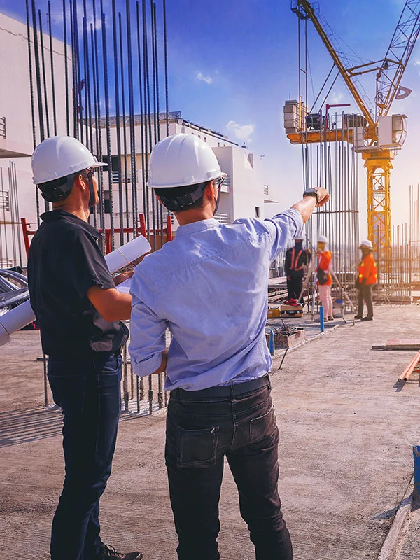 Two men with white hats doing construction management